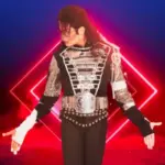 A Michael Jackson tribute artist poses with his arms out wearing clothing typical of the King of Pop
