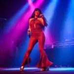Queen Selena tribute singer at Alexis Park Las Vegas performing in a red outfit.