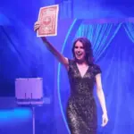 Jen Kramer performing a card trick onstage