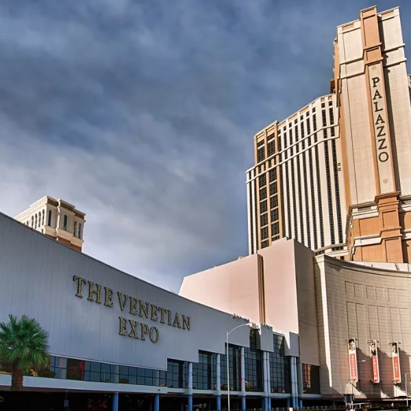 An exterior view of The Venetian Expo during the day with the sun glimmering off the hotel towers of the Palazzo Resort Las Vegas