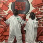A couple poses triumphantly after smashing every thing in sight at The Wreck Room Las Vegas.