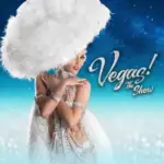 VEGAS! the Show performer in a white feathered costume.