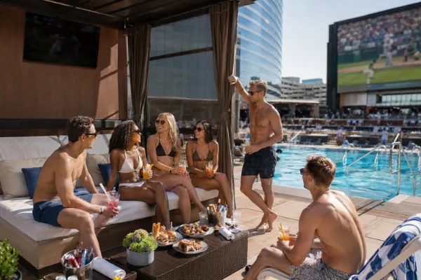 Adult guests enjoying food and drinks inside a poolside cabana at Circa Stadium Swim