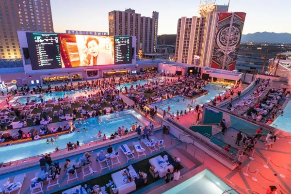 Stadium Swim at Circa Resort and Casino illuminated at night with its pools and enormous sports screen