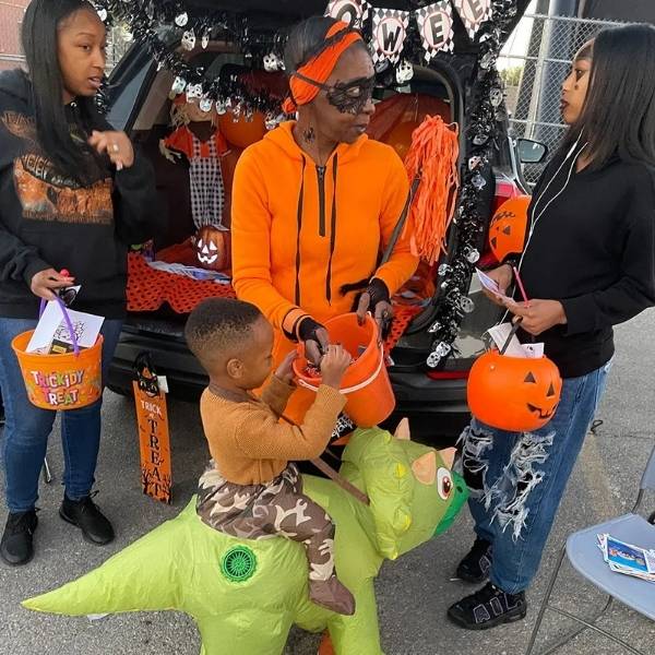 Family collecting Halloween candy at the Wicked Whitney trunk-or-treat event