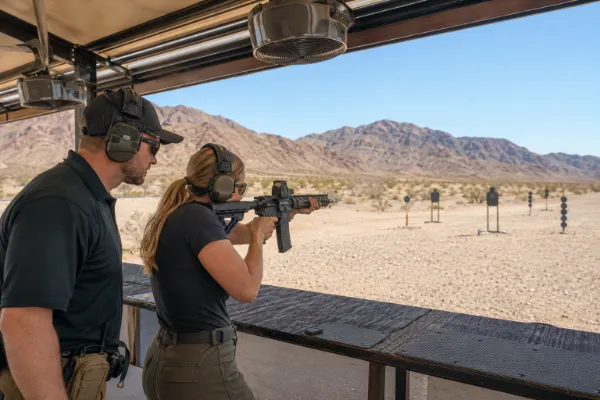 Adult guest firing a rifle under professional supervision at the Adrenaline Mountain outdoor range near Las Vegas.