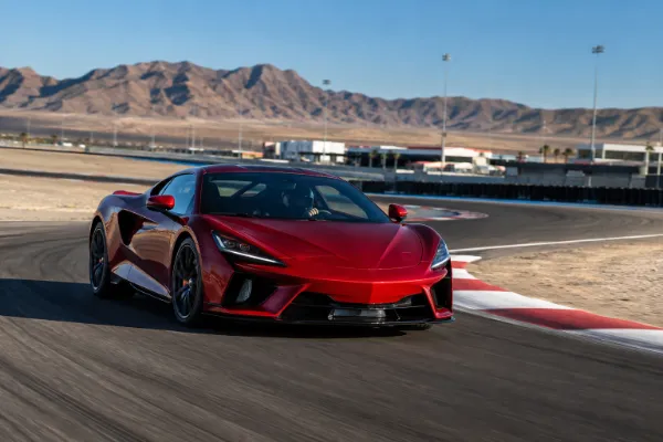 Red exotic performance car speeding around the professional racetrack at Las Vegas Motor Speedway.