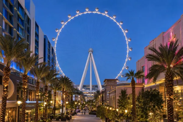 The illuminated High Roller Observation Wheel rises above the Las Vegas Strip and The LINQ Promenade at dusk.