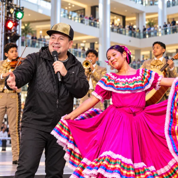 DJ Gabo hosts beside a folklórico dancer and youth mariachi musicians during the Mexican Independence Day celebration at Fashion Show Las Vegas.