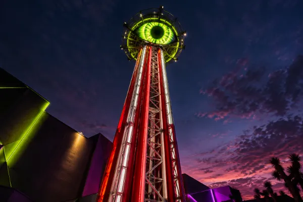 The giant glowing eye atop the Eye Dropper thrill ride at AREA15 in Las Vegas at dusk.