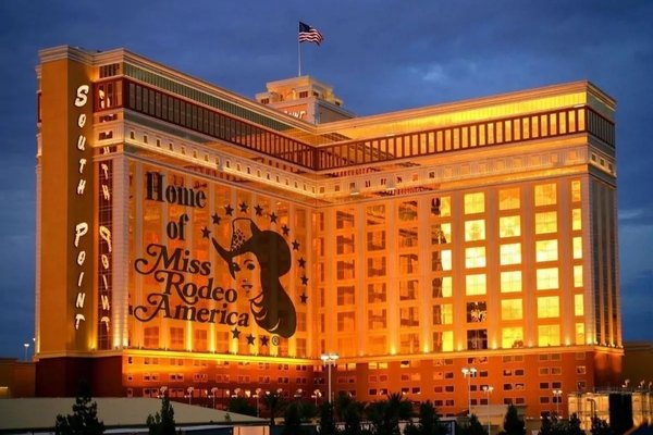 South Point Hotel illuminated at dusk with a large “Home of Miss Rodeo America” display on its exterior.