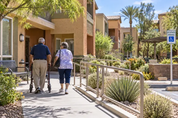 Older adults walk through an accessible Las Vegas apartment community with ramps, handrails, and desert landscaping.